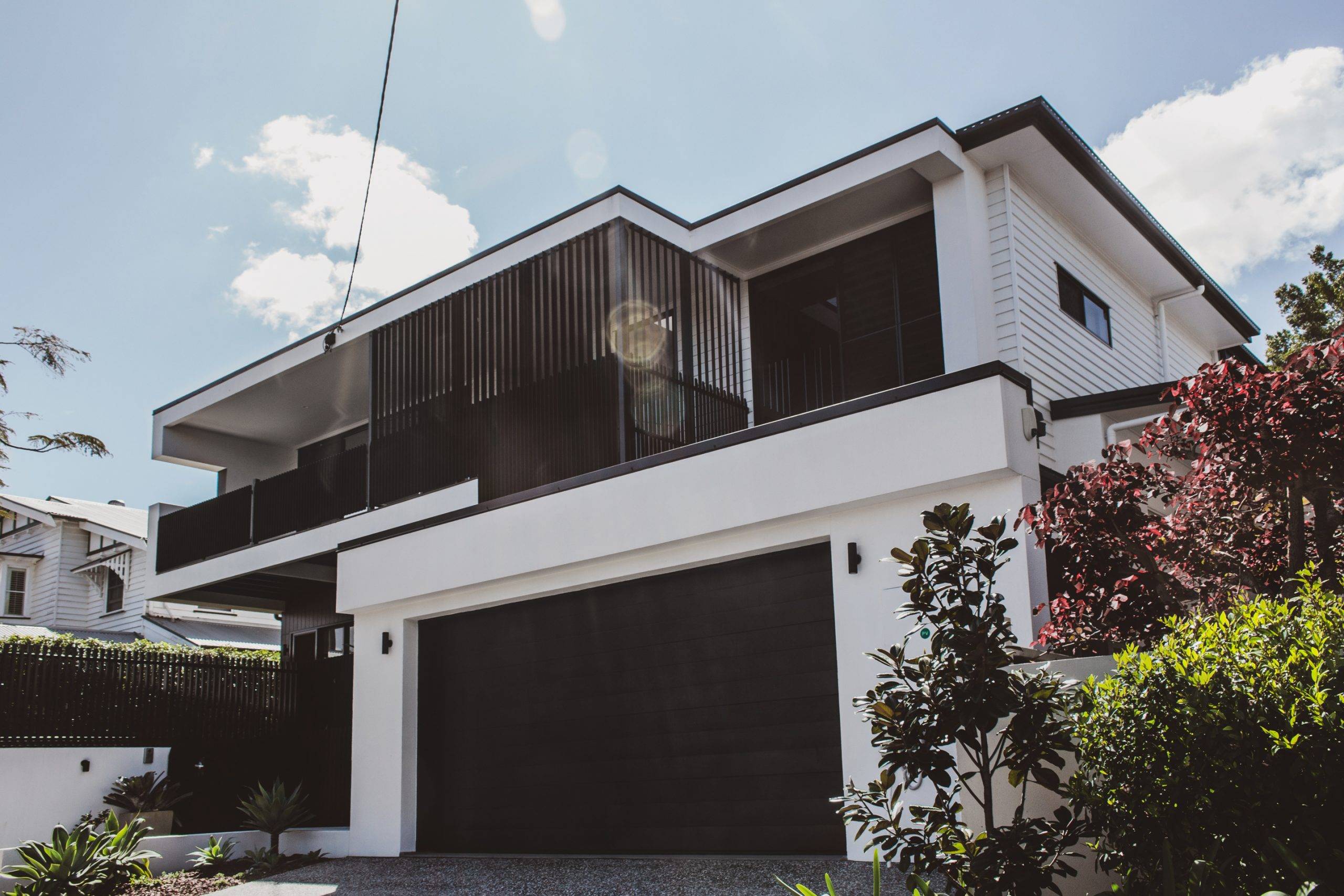 Reeve St Architect designed minimalist, modern home, Minimalist palette of white, black, stained timber, and terrazzo tiles, Traditional Character Area, traditional Queenslander style